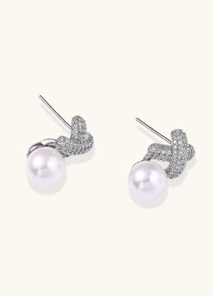 Elegant drop earrings with pavé crystal cross tops and round freshwater pearls on 14K gold plated brass setting.