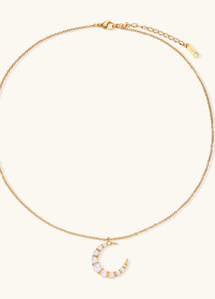 Delicate 18K gold plated necklace featuring crescent moon pendant with white shell pearl beads on neutral background.