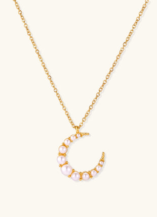 Delicate 18K gold plated necklace featuring crescent moon pendant with white shell pearl beads on neutral background.