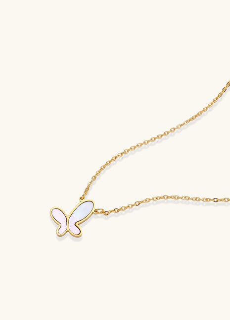 Delicate gold butterfly necklace with white mother of pearl wings on fine chain, displayed on neutral background.