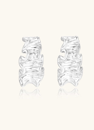 Textured gold-plated hoop earrings with flowing ripple design displayed on clean white background.