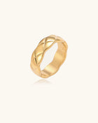 18K gold plated stainless steel ring with geometric twisted band design on neutral background