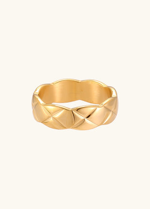 18K gold plated stainless steel ring with geometric twisted band design on neutral background