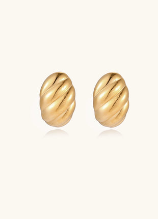 Pair of gold-plated twisted stud earrings with sculptural spiral design displaying elegant curved ridges on cream background.