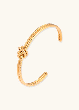18K gold-plated twisted rope cuff bracelet with decorative knot detail on white background, showing adjustable open design.