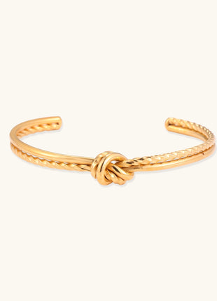 18K gold-plated twisted rope cuff bracelet with decorative knot detail on white background, showing adjustable open design.