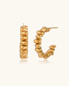 Gold-plated stainless steel earrings with twisted rope texture in various hoop sizes on neutral background.
