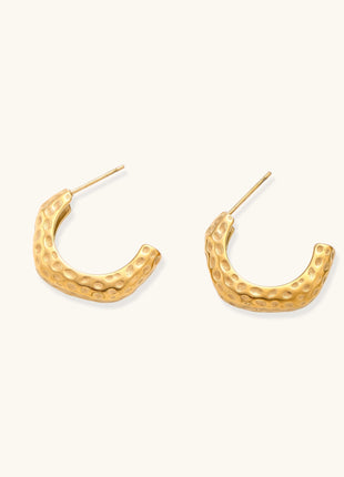 Textured gold-plated hoop earrings with dimpled surface pattern and post backs on neutral background.