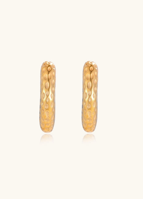 Textured gold-plated hoop earrings with dimpled surface pattern and post backs on neutral background.
