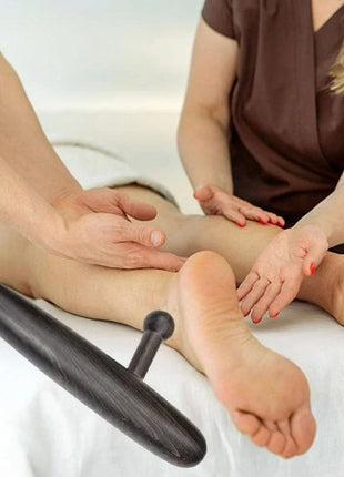 Therapist using thumb saver tool on client’s waist